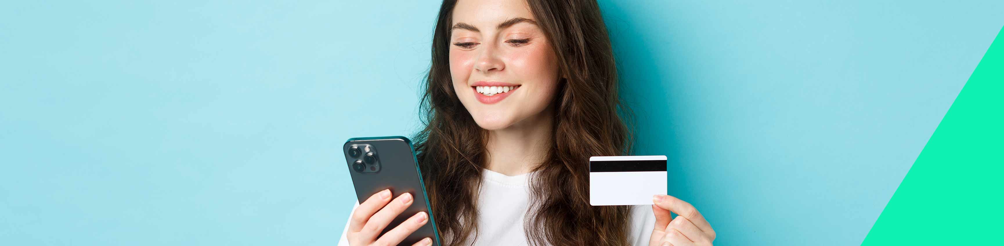 Une jeune femme paie un article en ligne avec sa carte de débit. 