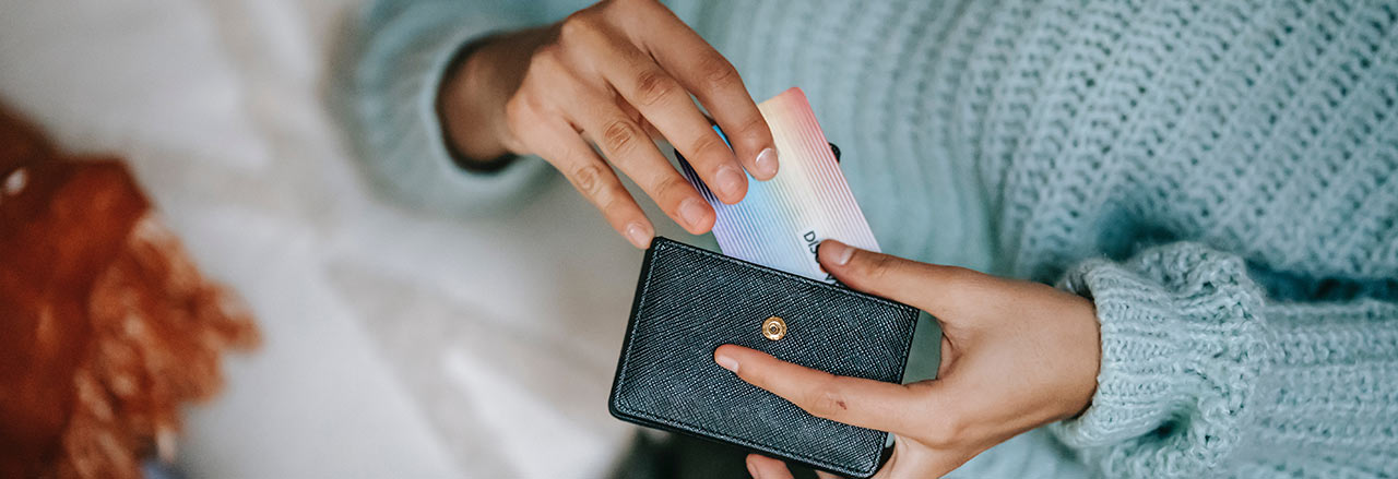 Une femme sort sa carte de crédit de son porte-monnaie.  